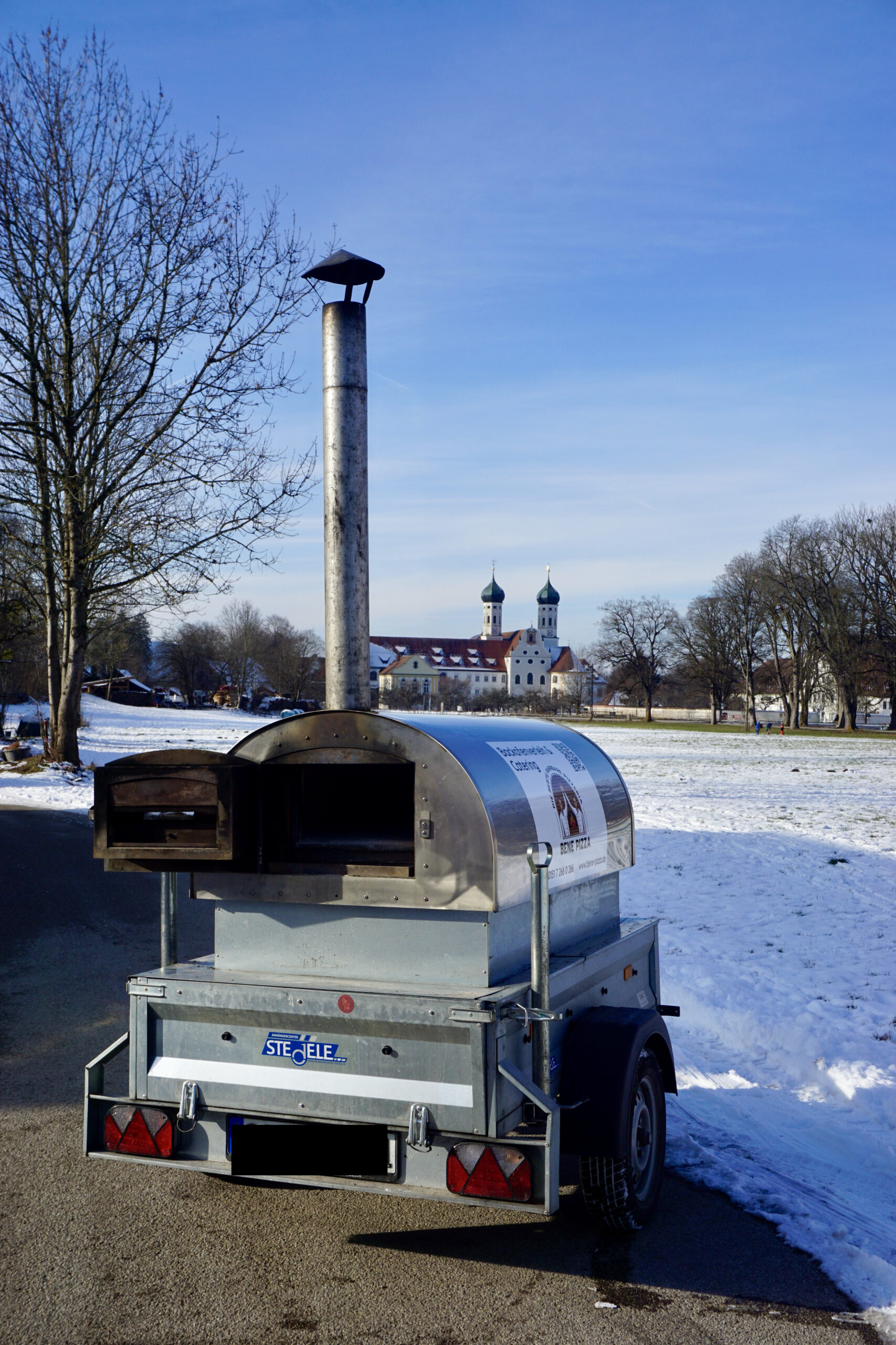 Mobiler Holzbackofen im Winter vor dem Kloster Benediktbeuern